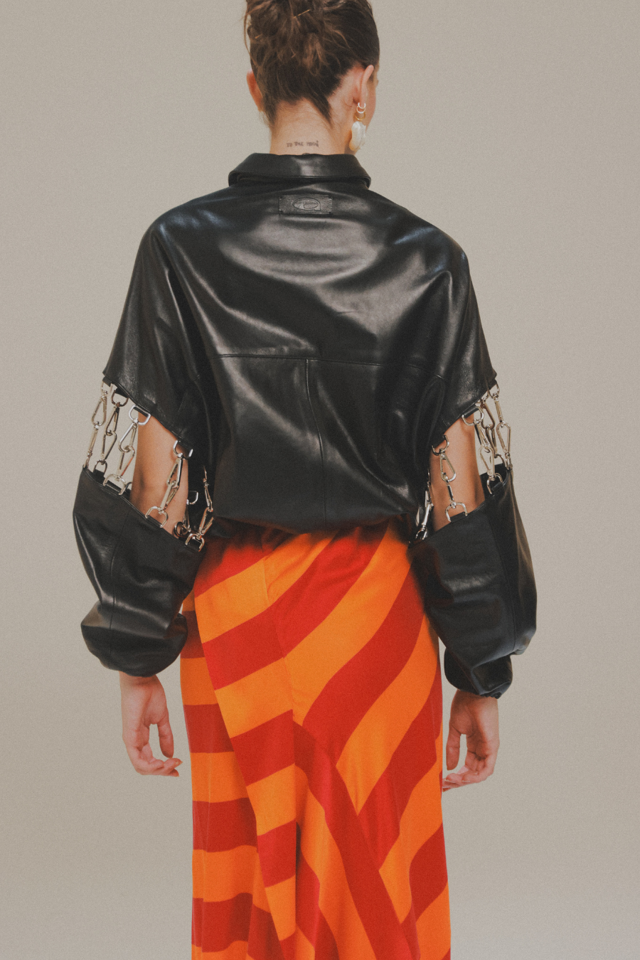 Chamarra Bomber Langosta de piel de cordero negra con mangas desmontables de Amkie Gamus, vista posterior en modelo.