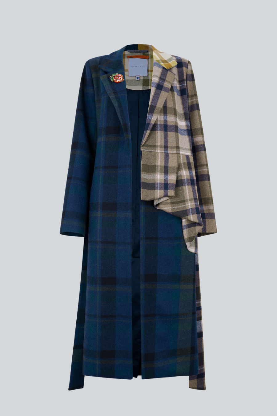 Abrigo Rionda de lana tartan con peplum asimétrico y broche de granada de Sandra Weil.