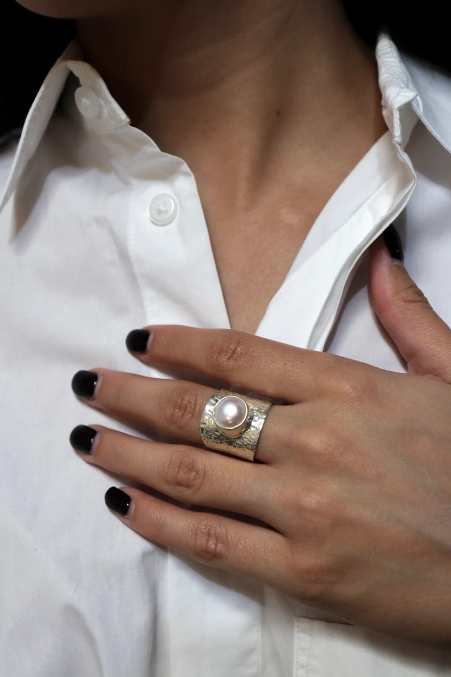 Anillo Centro de KARIZIA en plata .925 con cuerpo ancho texturizado y perla central vista en mano.