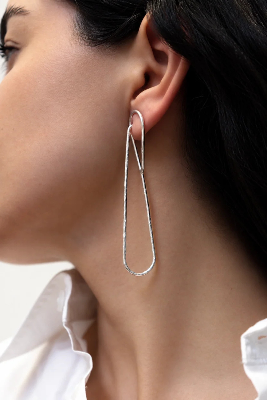 Aretes Trazo de KARIZIA en plata .925 con diseño lineal alargado y acabado texturizado vista en modelo