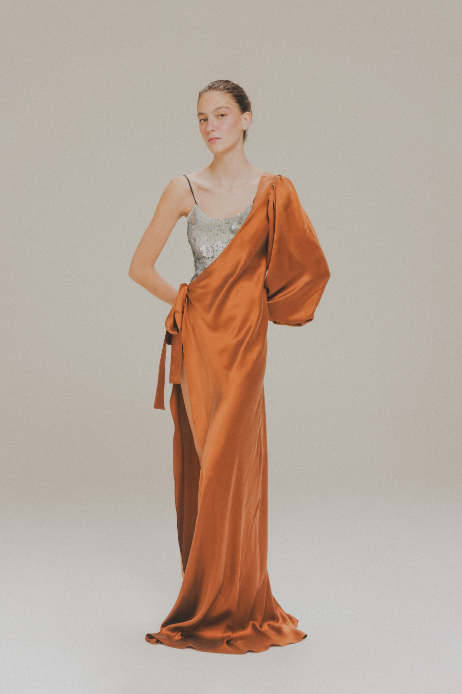 Vestido largo envolvente asimétrico con bustier de lentejuelas de Amkie Gamus, vista frontal en modelo.