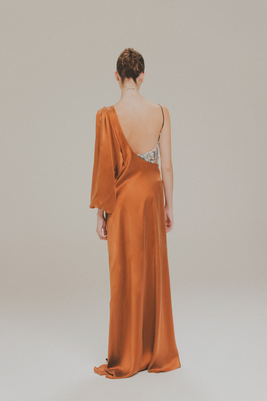 Vestido largo envolvente asimétrico con bustier de lentejuelas de Amkie Gamus, vista posterior en modelo.