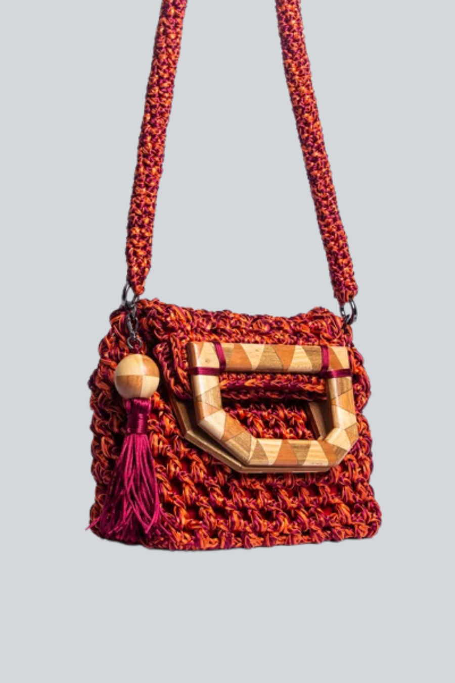 Bolsa Cabana tejida de Catarina Mina con asa de madera color naranja.