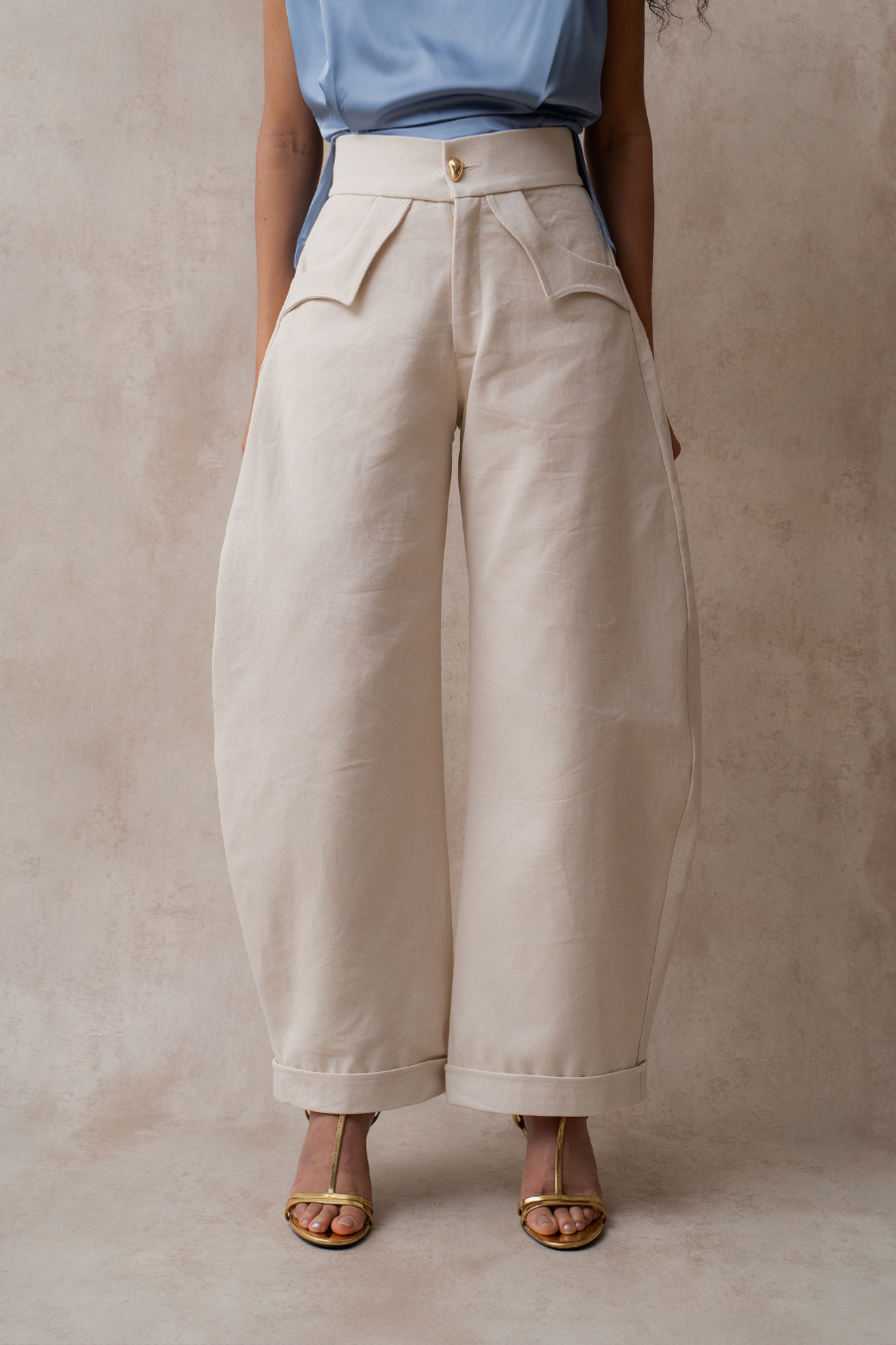 Detalle del botón distintivo de Arial 12 en el Pantalón Ola de denim ivory


